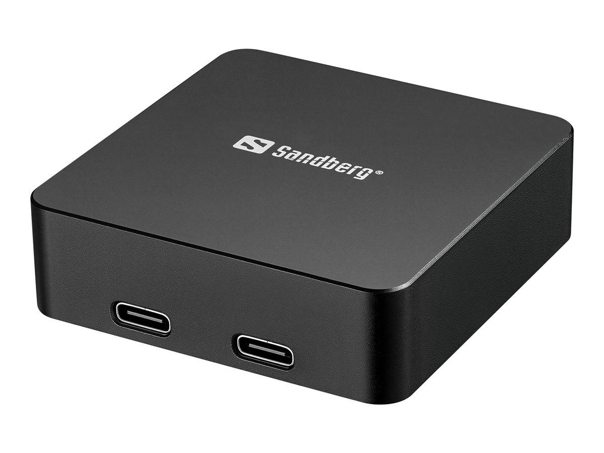 Ein schwarzer Sandberg USB-Hub mit zwei USB-C-Anschlüssen, aus einem Winkel betrachtet, mit dem Sandberg-Logo auf der Oberfläche.