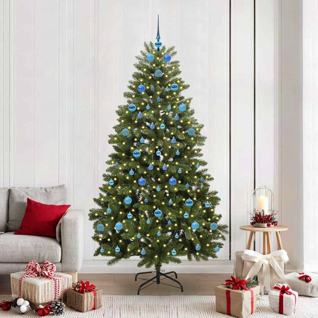 Dekorierter Weihnachtsbaum mit blauen Kugeln und Lichtern, umgeben von verpackten Geschenken in einem Wohnzimmer neben einem Sofa und Kerzen.