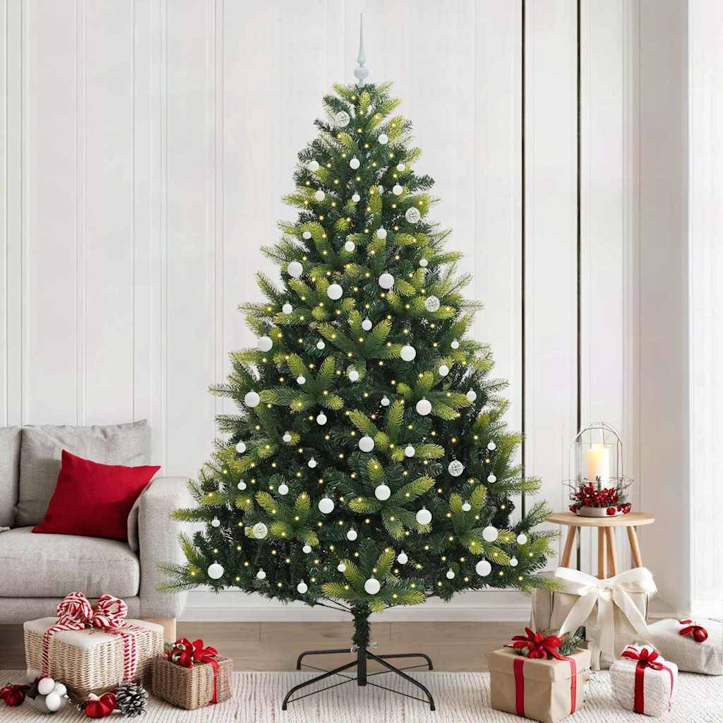 Ein geschmückter Weihnachtsbaum mit weißen Christbaumkugeln und Lichtern steht im Wohnzimmer. Geschenke, in rot und weiß verpackt, liegen unter dem Baum.