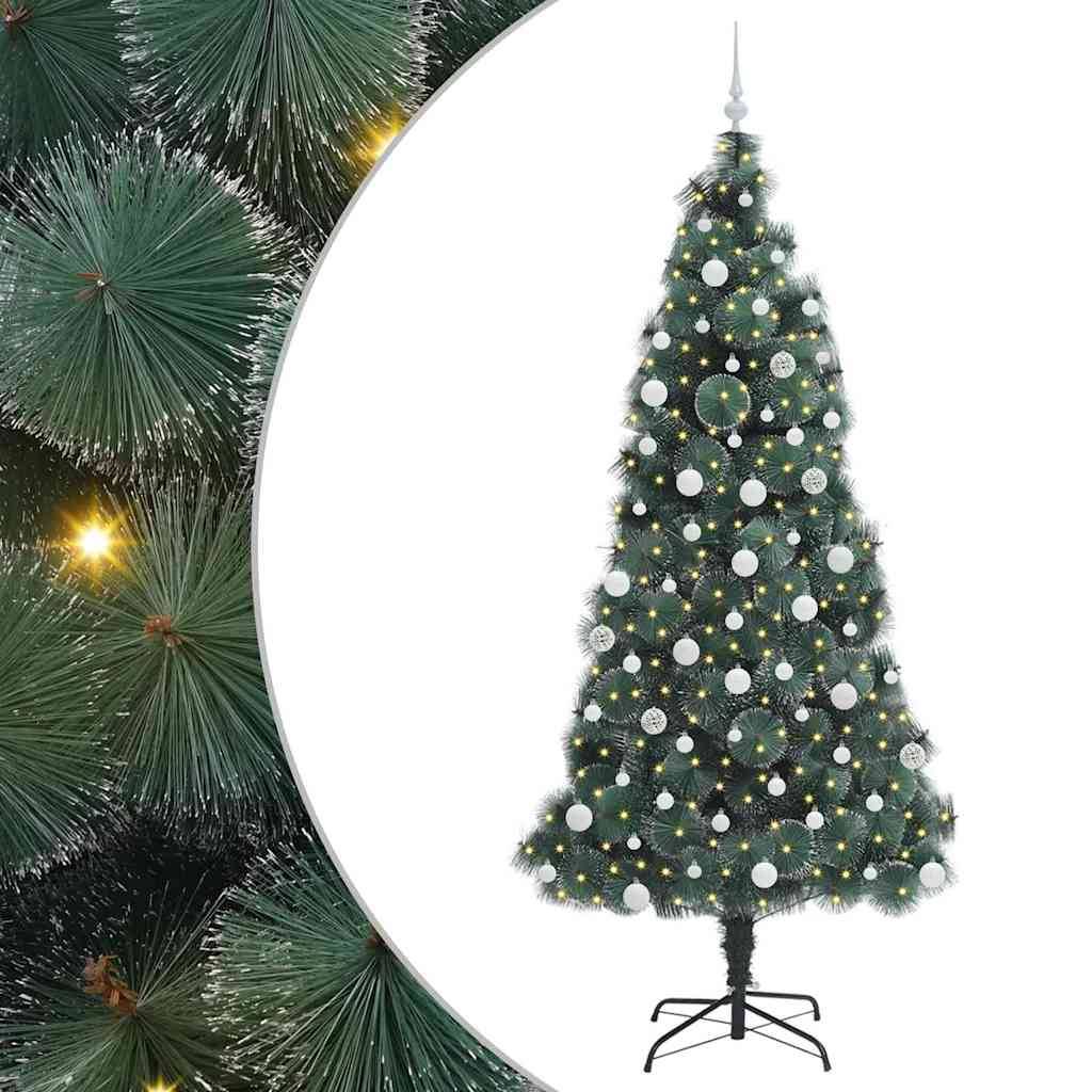 Ein geschmückter Weihnachtsbaum mit silbernen und weißen Kugeln und Lichtern steht auf einem Sockel. Kiefernzweige mit Lichtern befinden sich auf der linken Seite.