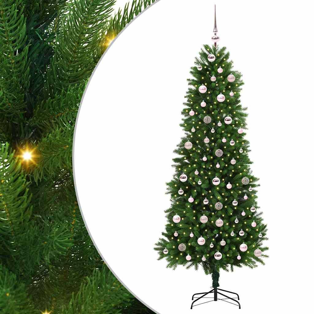 Ein hoher künstlicher Weihnachtsbaum, geschmückt mit gleichmäßig angeordneten silbernen und weißen Weihnachtskugeln, vor einem grünen Hintergrund mit festlicher Beleuchtung.