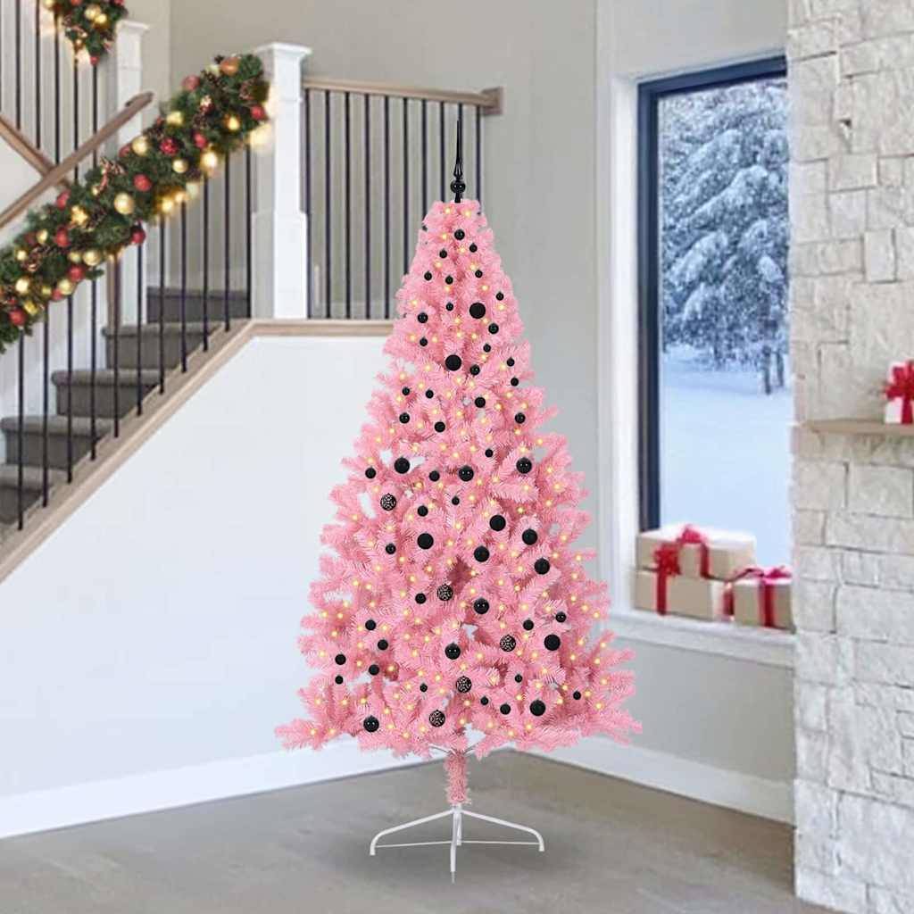 Ein rosa Weihnachtsbaum, geschmückt mit schwarzen Christbaumkugeln, steht in einem festlich dekorierten Raum. Girlanden schmücken das Treppengeländer, und draußen ist Schnee zu sehen.