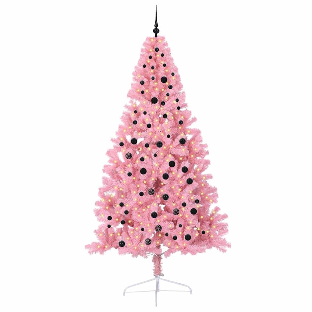Ein künstlicher rosa Weihnachtsbaum, geschmückt mit schwarzen und goldenen Christbaumkugeln, der auf einer weißen Basis vor einem einfarbigen weißen Hintergrund steht.