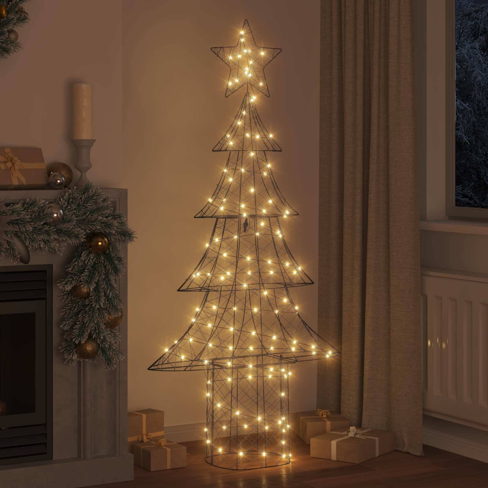 Drahtgitter-Weihnachtsbaum mit Stern an der Spitze, glühend mit warmem Licht, neben einem dekorierten Kamin und eingepackten Geschenken, was eine gemütliche Atmosphäre schafft.