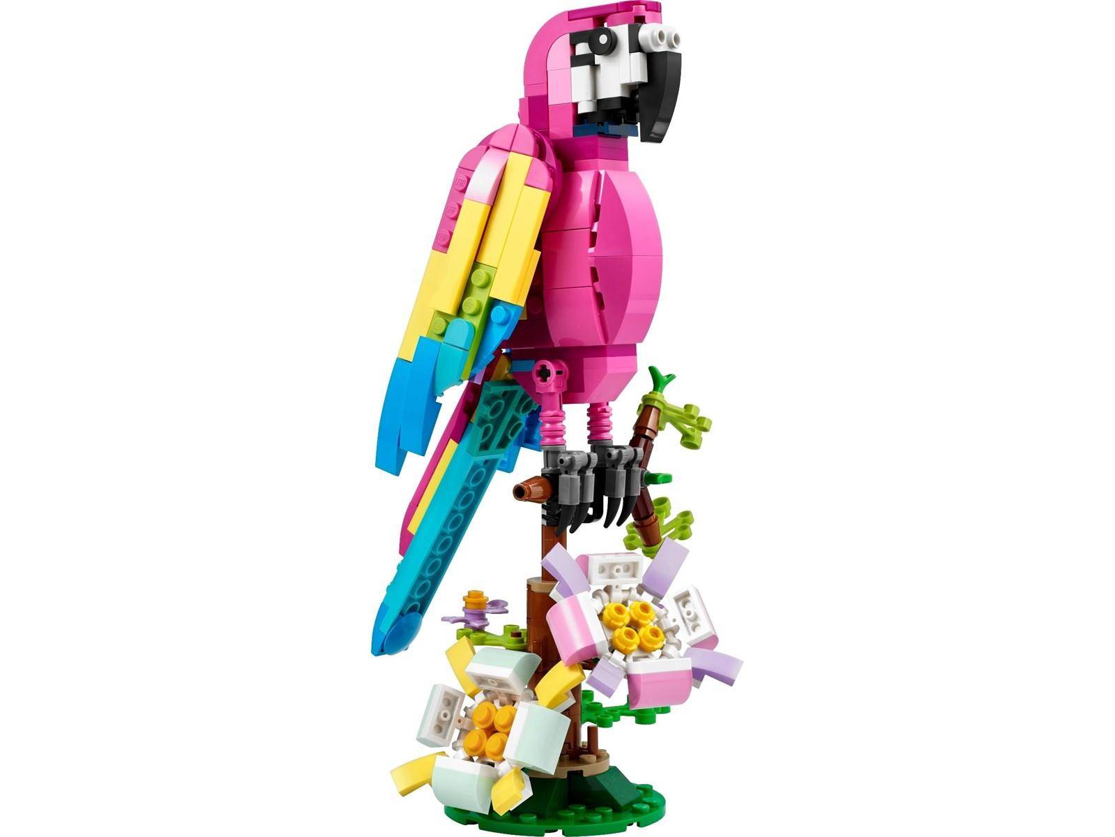 Buntes LEGO-Papageimodell auf einer kleinen blütenverzeierten Stange vor weißem Hintergrund.