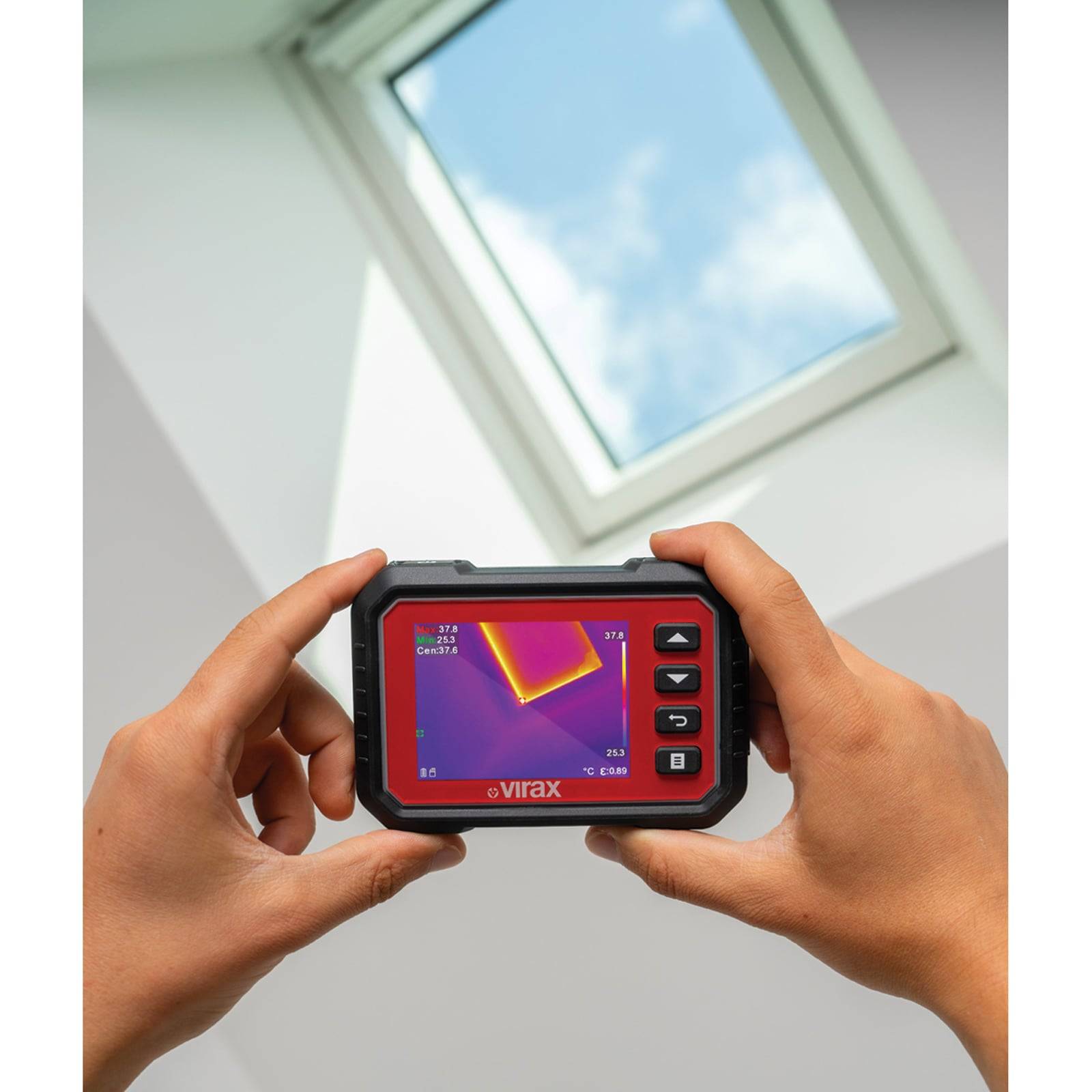 Hände halten ein Wärmebildgerät, das einen Wärmebildblick auf ein Oberlicht zeigt. Der Bildschirm zeigt Temperaturunterschiede.