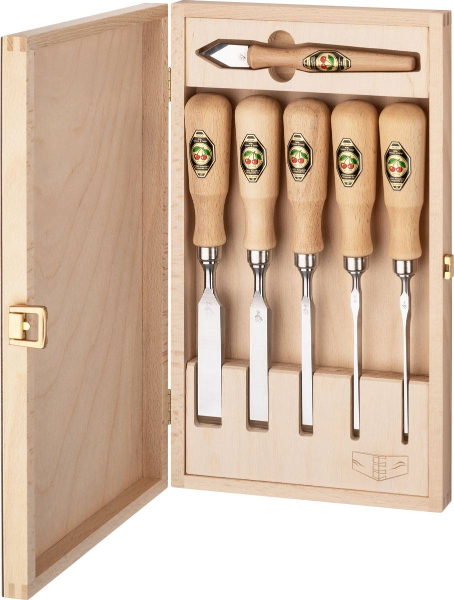 Eine Holzkiste mit fünf Meißeln mit Holzgriffen, ordentlich aufrecht angeordnet. Jeder Meißelgriff hat ein Etikett mit Branding.