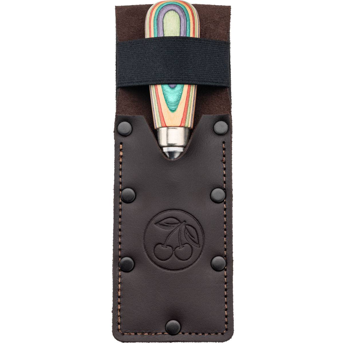 Eine Lederscheide hält ein Werkzeug mit regenbogenfarbenem Griff, auf dessen Vorderseite ein Kirschenlogo eingeprägt ist.