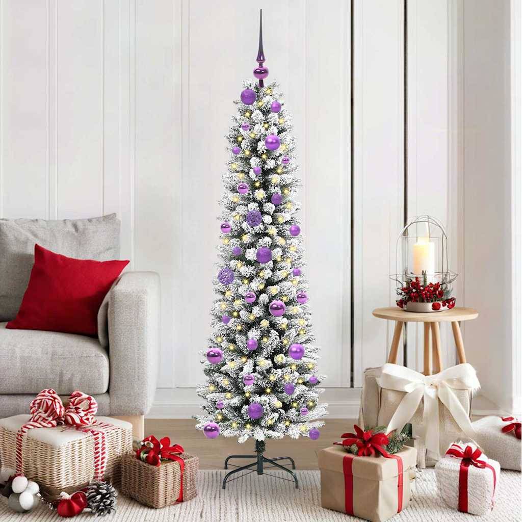 Ein hoher, schmaler Weihnachtsbaum, der mit violetten Kugeln und weißen Ornamenten geschmückt ist, steht in einem gemütlichen Wohnzimmer mit minimalistischer Einrichtung.