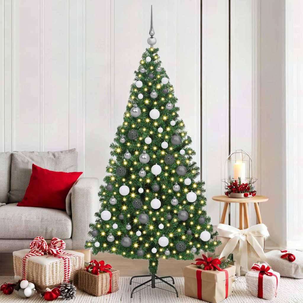 Ein geschmückter Weihnachtsbaum mit weißen und silbernen Ornamenten steht in einem Wohnzimmer, mit in Rot und Gold verpackten Geschenken darunter.