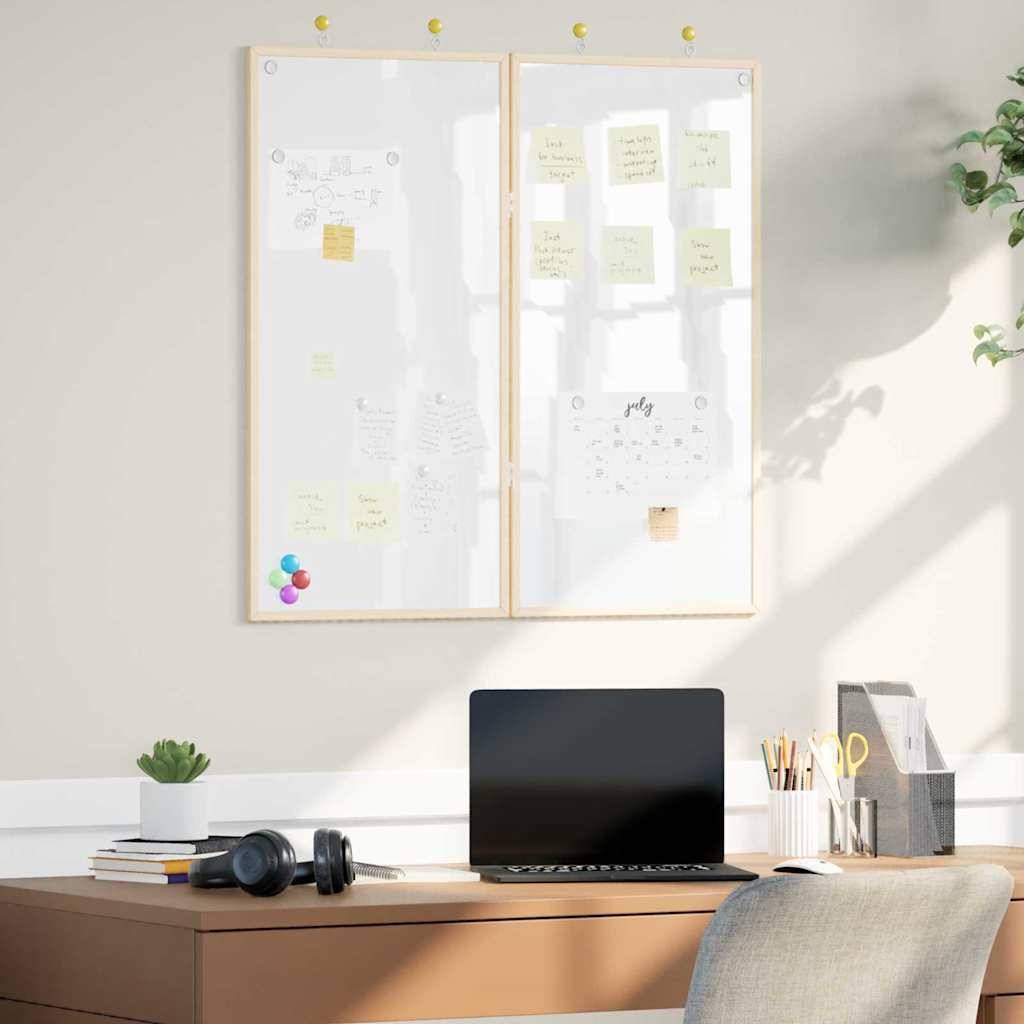 Ein aufgeräumter Arbeitsplatz zeigt einen Holzschreibtisch mit einem Laptop, einem Notizbuch und Kopfhörern. Zwei Whiteboards darüber präsentieren Notizen und Diagramme.