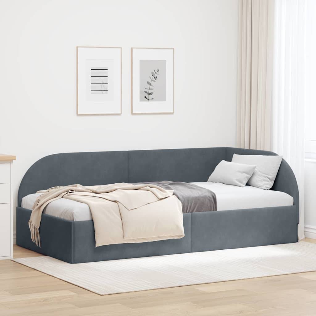 Ein modernes Schlafzimmer mit einem grau gepolsterten Tagesbett, Kissen und einer beigen Wurfdecke. Zwei gerahmte botanische Drucke hängen an der Wand darüber.