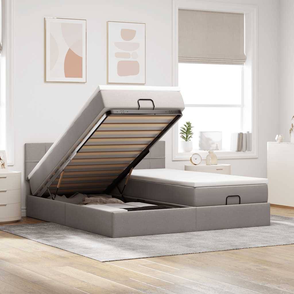 Ein modernes Schlafzimmer mit einem grauen Ottomane-Bett, das geöffnet den Stauraum zeigt. Helle Wände, abstrakte Kunst und Sonnenlicht schaffen eine gemütliche Atmosphäre.