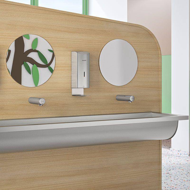 Modernes Handwaschbecken mit zwei runden Spiegeln, einem zentralen Seife- oder Desinfektionsmittelspender und einem Edelstahlwaschbecken an einer holzvertäfelten Wand