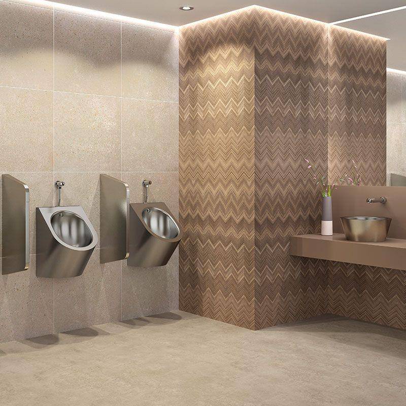 Modernes öffentliches Badezimmer mit zwei wandmontierten Urinalen, gefliesten Wänden und einem Waschbereich mit gemusterter Akzentwand.