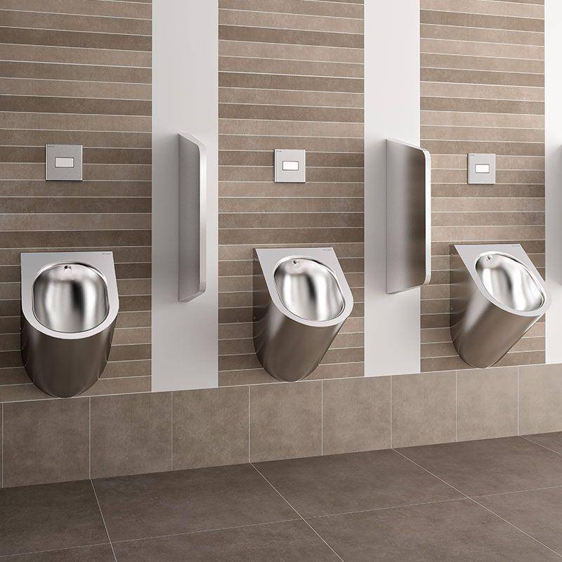 Moderne öffentliche Toilette mit drei an der Wand montierten Edelstahl-Urinals auf gestreiften Fliesenwänden und Spültasten über jedem Urinal.