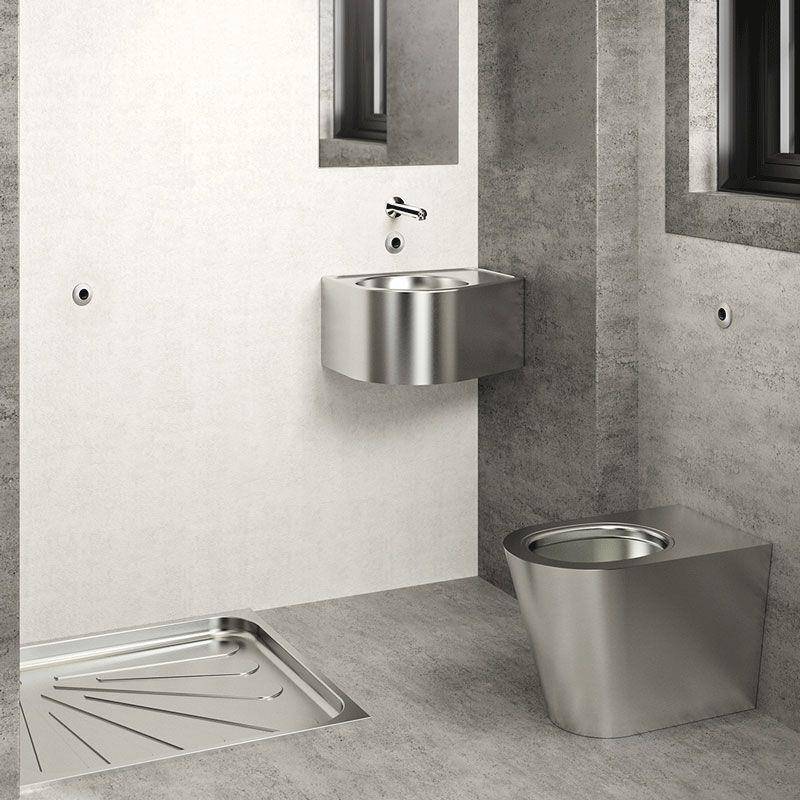 Modernes Badezimmer mit an der Wand montiertem Edelstahlwaschbecken und Toilette, plus Bodenablauf für die Dusche in einem minimalistischen Raum in Grau und Weiß.