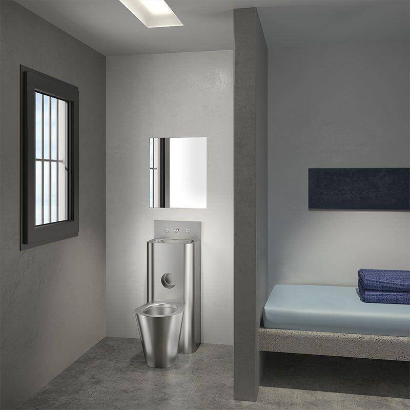Kleine moderne Zelle mit Metalltoilette und Waschbecken, schmalem vergittertem Fenster, Wandspiegel und einfachem Bett, getrennt durch eine Trennwand.