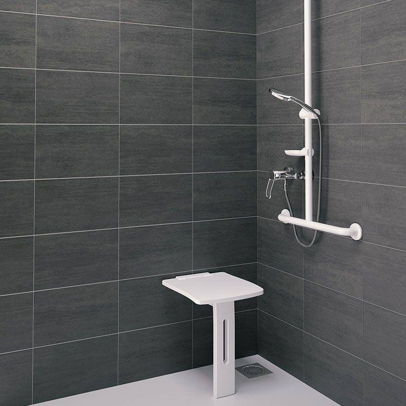 Barrierefreie Dusche mit wandmontierten Griffen, abnehmbarem Duschkopf und klappbarem Sitz in einer gefliesten Eckduschkabine.