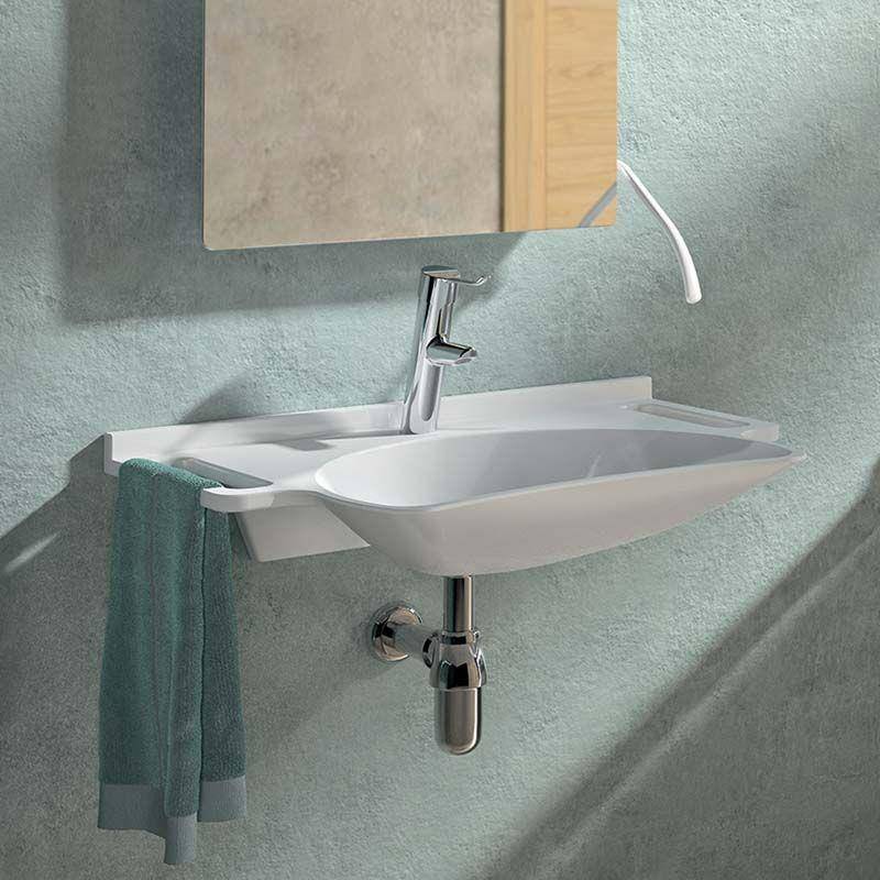 Modernes an der Wand montiertes Badezimmerbecken mit Chromarmatur und Spiegel, ein Handtuch über der Seite drapiert, vor einer strukturierten grünen Wand.