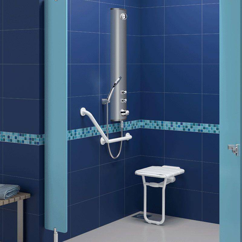Begehbare Duschkabine mit wandmontiertem Sitz, Haltegriffe und Handbrause in einem gekachelten blauen Badezimmer.