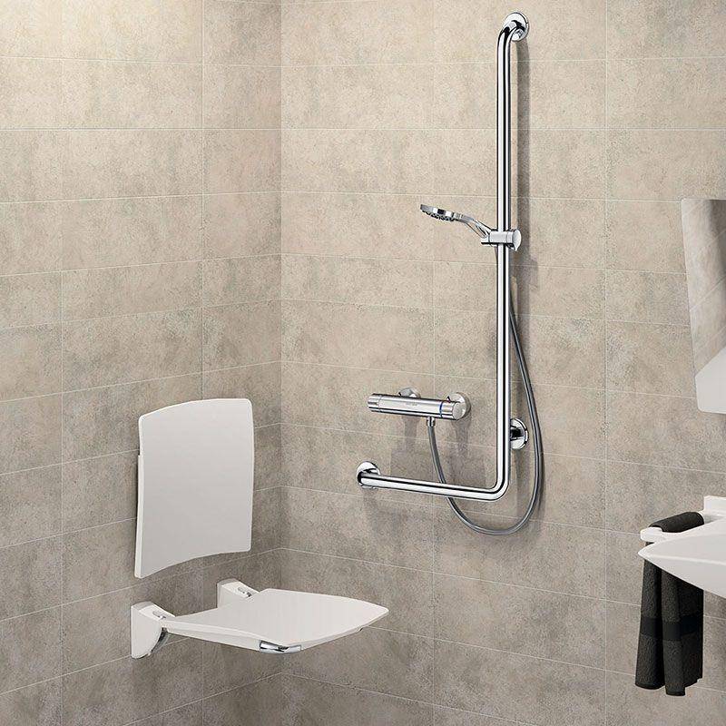 Barrierefreie Duschanlage mit einem hochklappbaren Wandsitz und Haltegriffe neben einem Handbrausekopf an einer gefliesten Badezimmerwand.