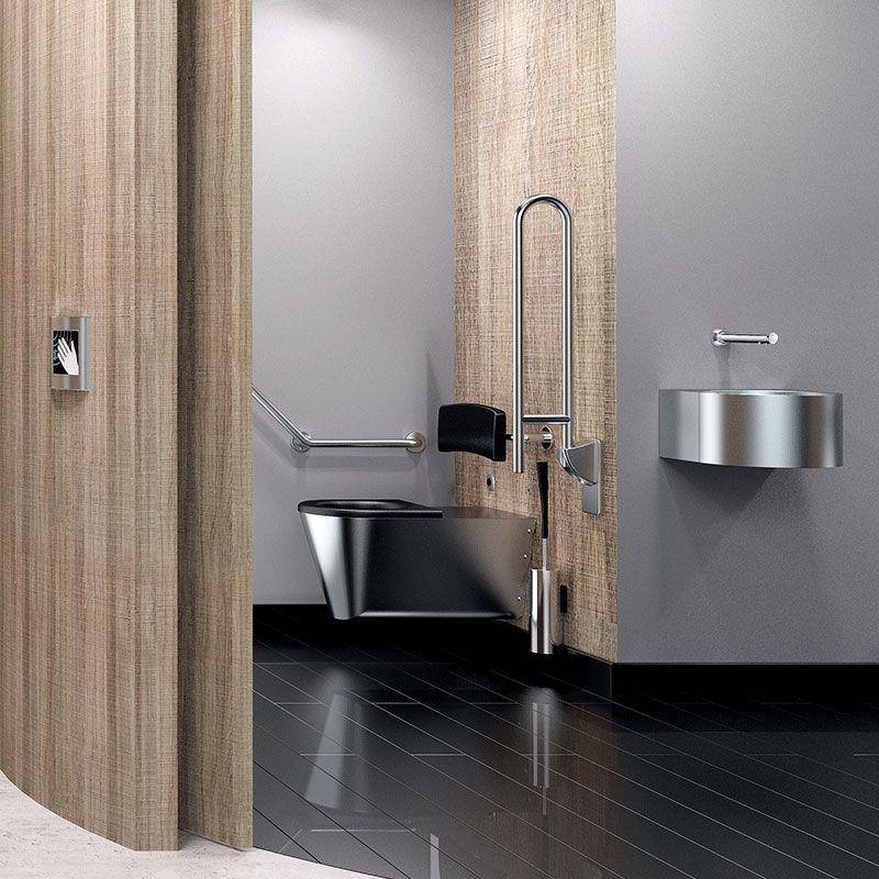 Barrierefreie Toilettenkabine mit rollstuhlgerechter Toilette, Haltegriff und Edelstahlwaschbecken in einer modernen Einrichtung.