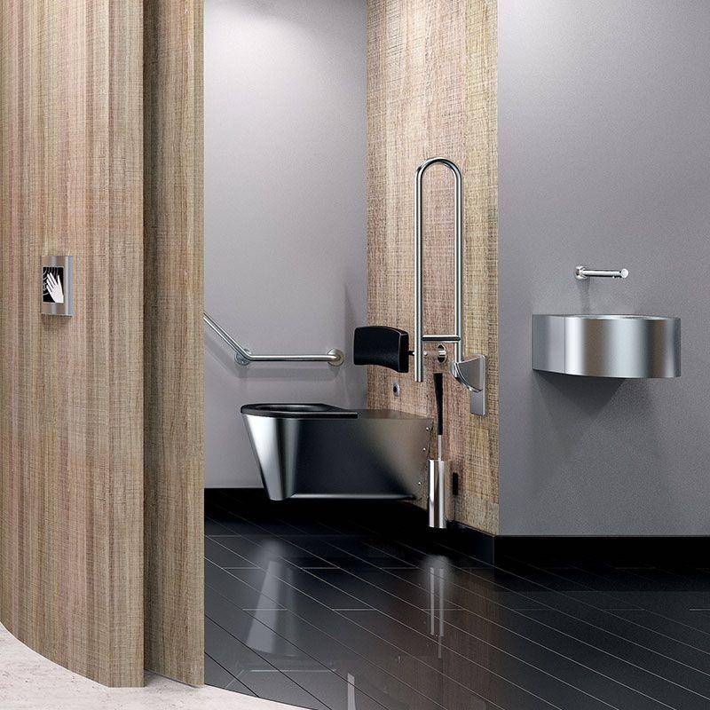 Zugängliche Toilettenkabine mit offener Tür, die eine wandmontierte Toilette, Haltegriffe und ein Edelstahlwaschbecken in einem barrierefreien Badezimmer zeigt.