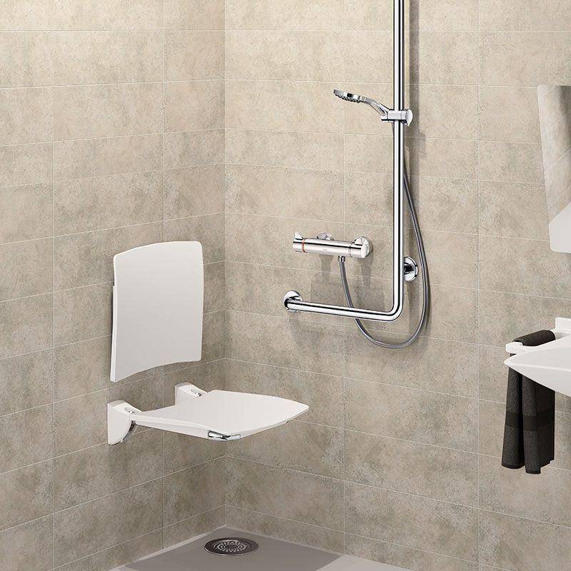 Zugängliche Duschec ke mit einem hochklappbaren Wandsitz, Haltegriffe und einer Handbrause in einem gefliesten Badezimmer.