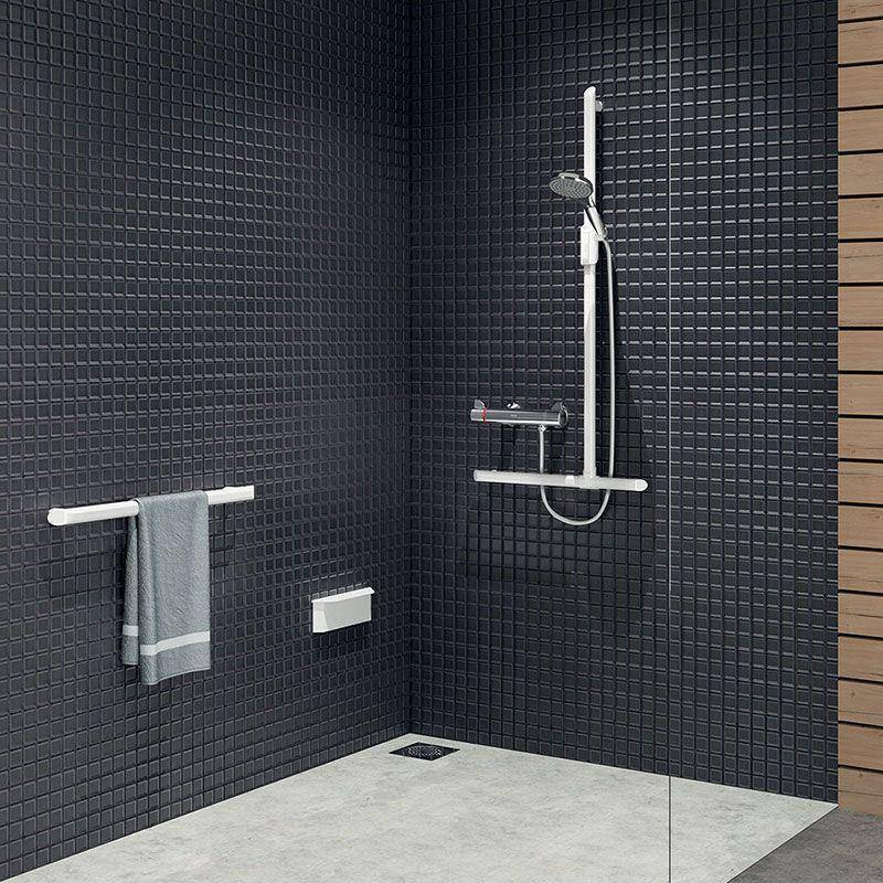 Modernes Badezimmer mit schwarzen gekachelten Wänden, hellem Betonboden, wandmontierter Handtuchstange, Regal und weißer Handbrause.