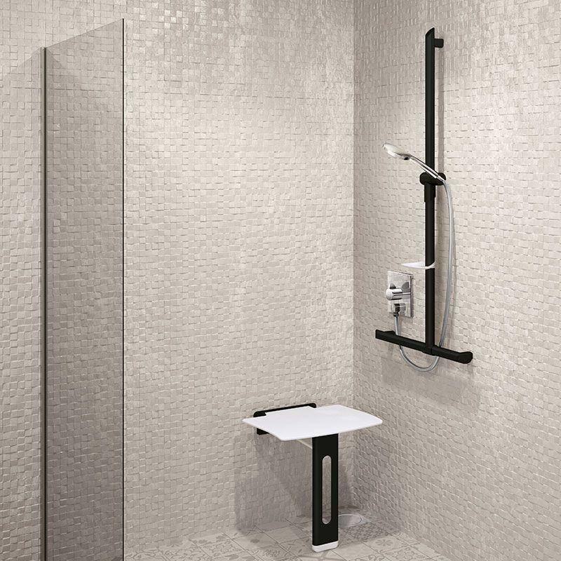 Moderner Duschbereich mit Fliesenverkleidung, Glastrennung, wandmontierter Dusche und einem kleinen klappbaren Sitz/Regal.