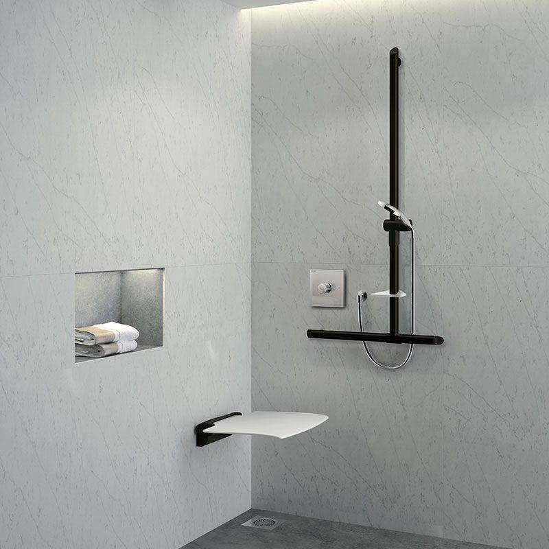 Moderne gekachelte Duschkabine mit Handbrause, Haltegriff, klappbarem Sitz und eingelassener Ablage mit Handtüchern.
