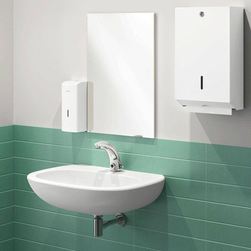 Modernes Waschbecken mit Spiegel, wandmontierter Seife und Papiertuchspender sowie grüner Fliesenpaneele.
