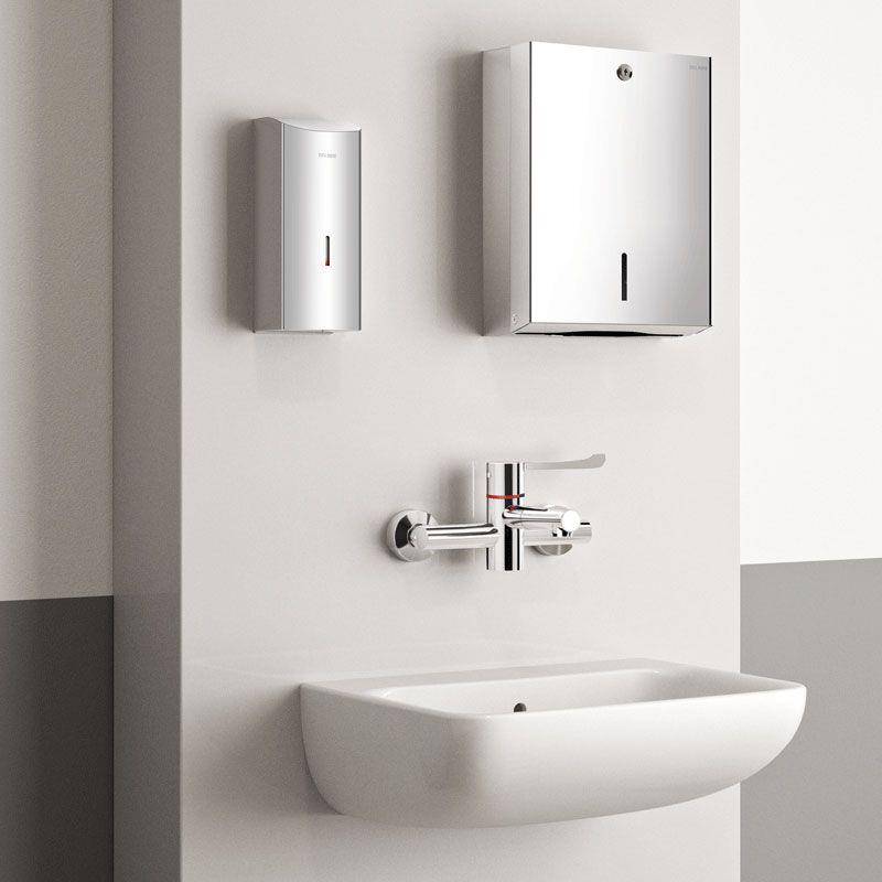 Modernes, wandmontiertes Waschbecken mit Chromarmatur und zwei Edelstahl-Spendern oben, gezeigt vor einer minimalistischen Badezimmerwand.