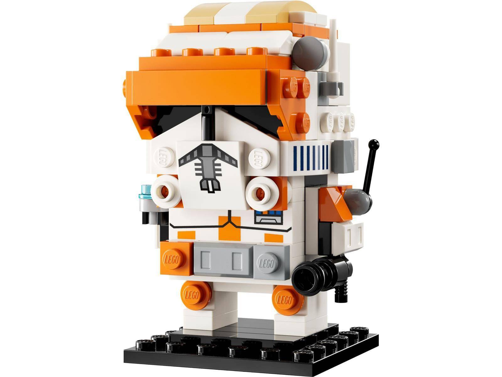 LEGO-ähnliche Astronauten-Minifigur in Weiß und Orange, stehend auf einem schwarzen Sockel mit Rucksack und helmähnlichem Kopfteil.