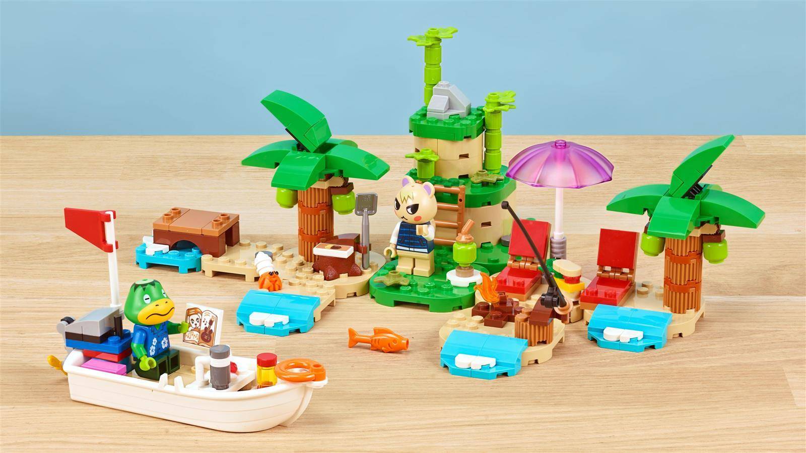 LEGO-artiges tropisches Inselspielset mit Palmen, Strandstühlen, Sonnenschirmen, kleinem Boot und Tierfiguren auf einem Holztisch.