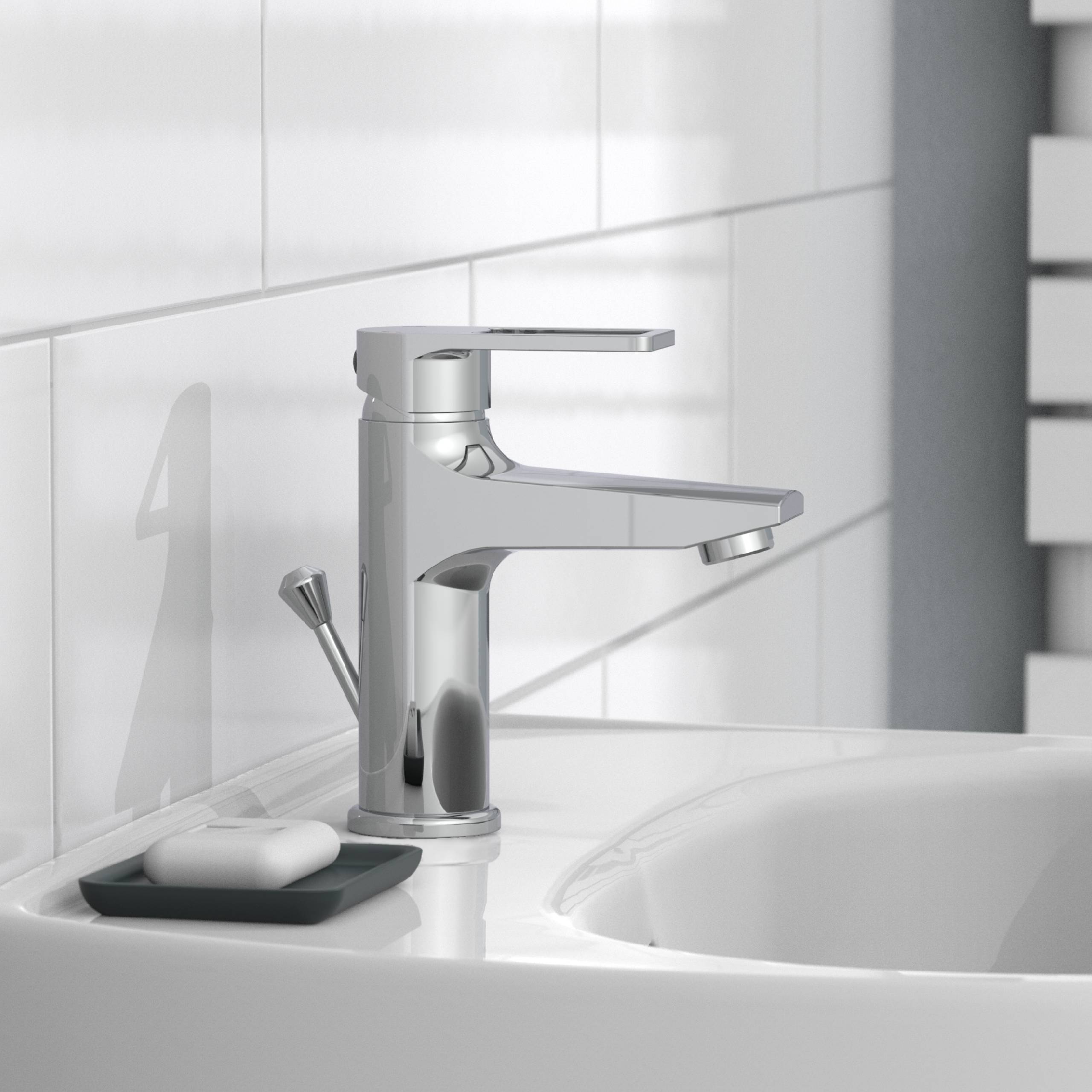 Chrom-Einhebel-Badezimmerhahn neben einem Waschbecken und einer Seifenschale in einem modernen weißen Badezimmer.