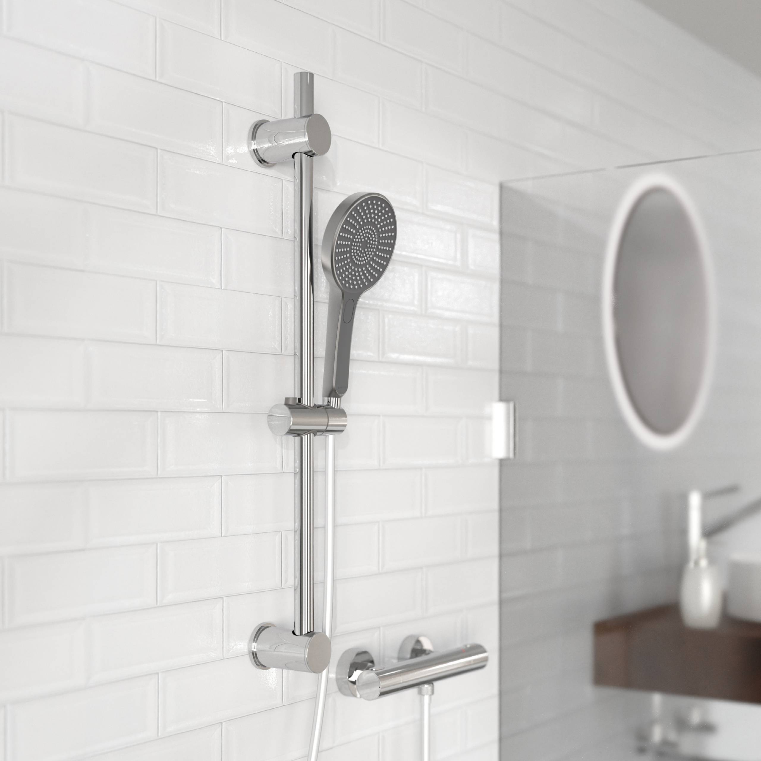 „Eine moderne Duschbrause, die an einer weißen gefliesten Badezimmerwand montiert ist, wobei ein rundes Spiegels und ein Waschbecken im Hintergrund teilweise sichtbar sind.