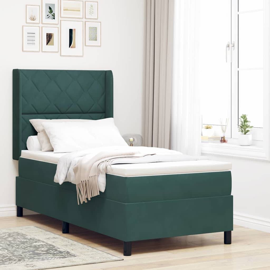 Ein ordentlich gemachtes Bett mit einem grün gepolsterten Kopf- und Fußteil, einem weißen Bettdecken und beigen Decken in einem hellen Schlafzimmer mit gerahmten Kunstwerken.