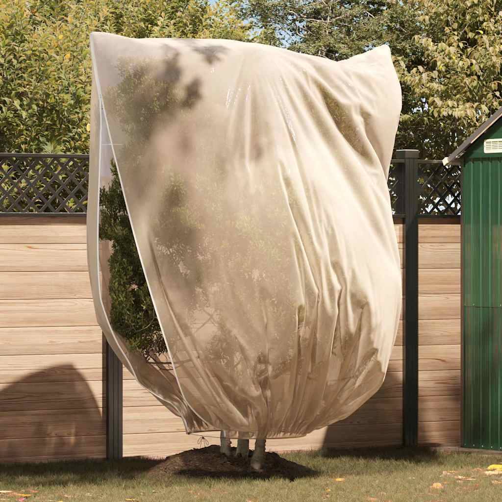Ein Baum in einem Garten ist mit einem großen, beigen Stoff zum Schutz bedeckt. Ein Holzzaun und eine grüne Struktur sind im Hintergrund sichtbar.