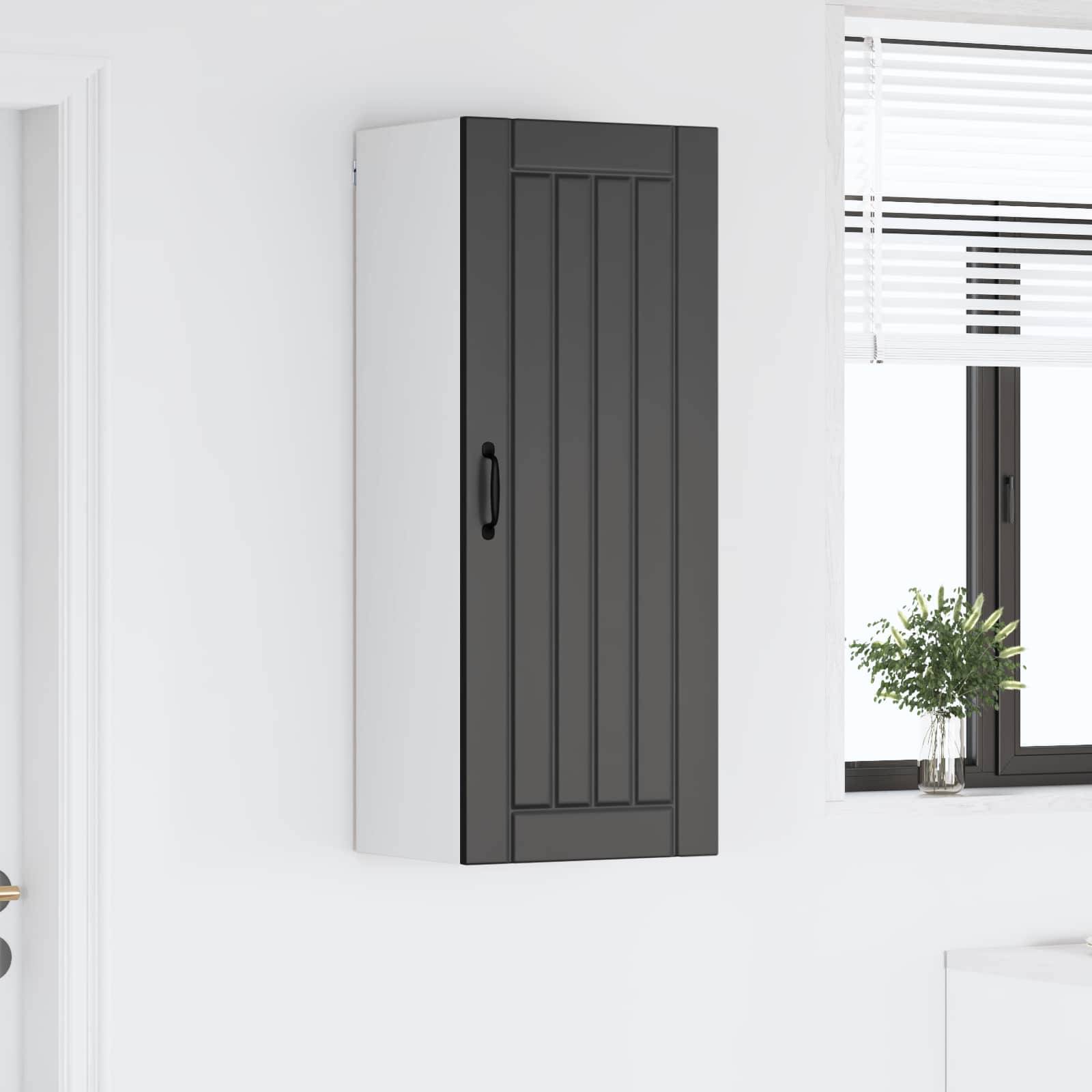 Ein hoher, schwarz-weißer Schrank, der an einer weißen Wand befestigt ist, in der Nähe eines Fensters mit teilweise geöffneten Jalousien, die Licht hereinlassen.