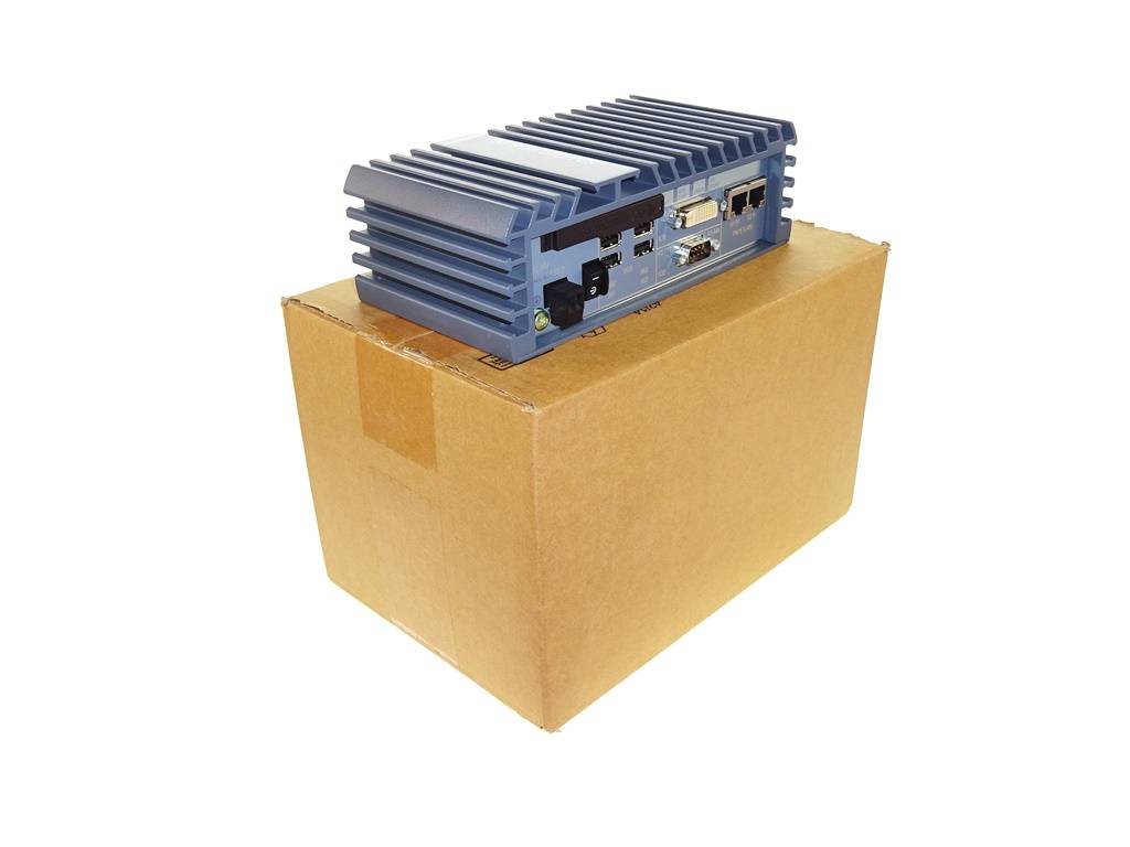 Ein blaues elektronisches Gerät mit Kühlkörper steht auf einem verschlossenen Versandkarton vor weißem Hintergrund.