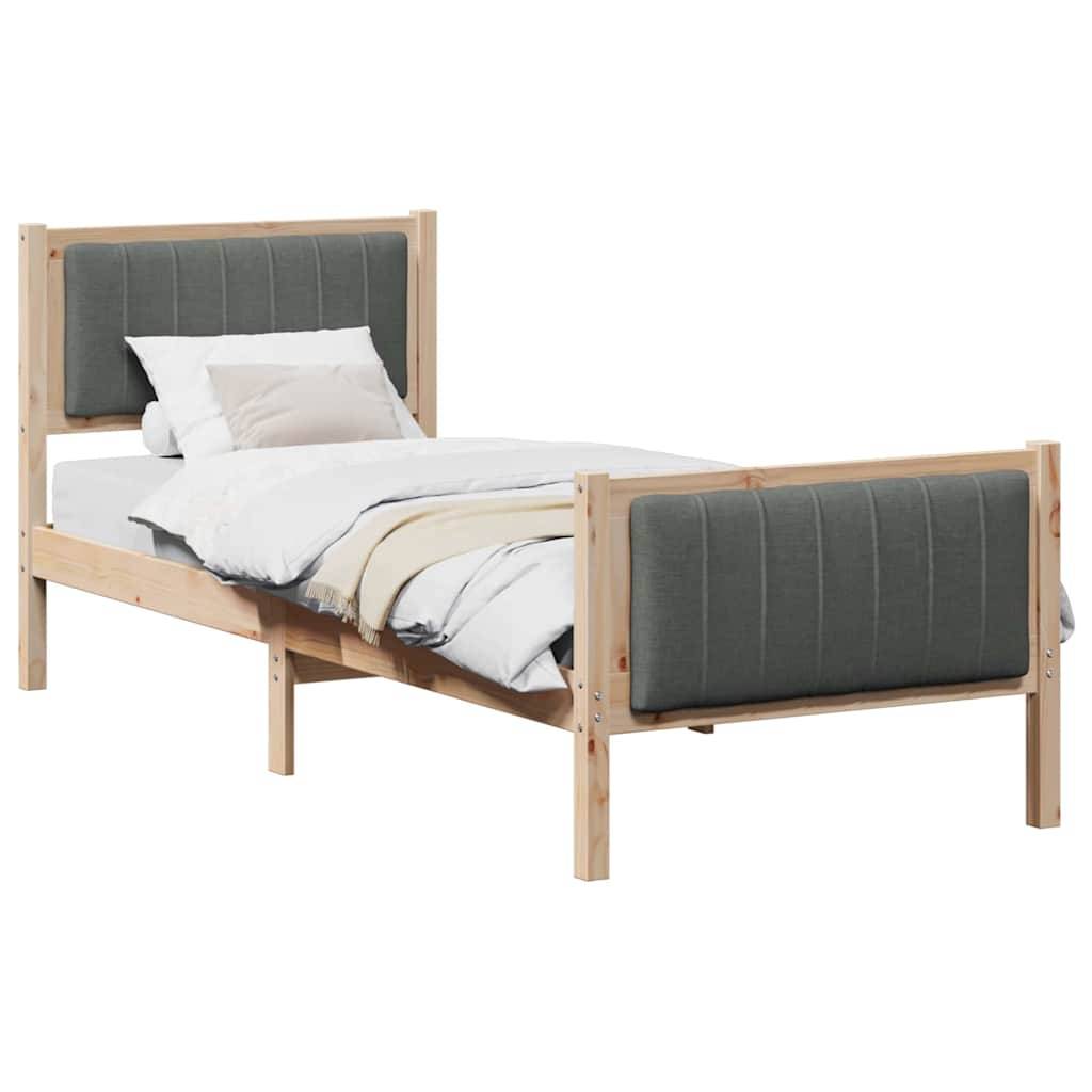 Ein Holzbettgestell mit grauem gepolstertem Kopfteil und Fußteil, ausgestattet mit weißer Bettwäsche und Kissen.