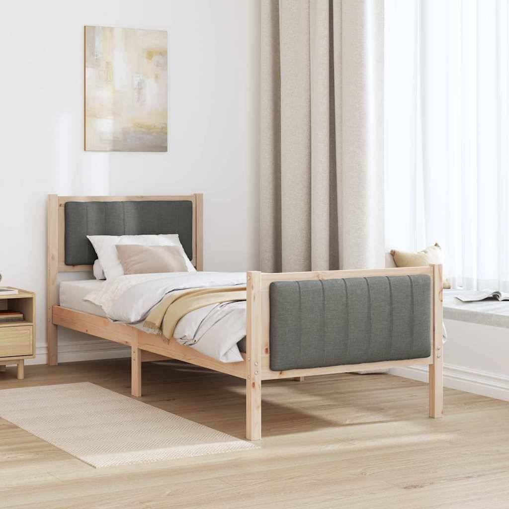 Minimalistisches Einzelbett mit grau gepolstertem Kopfteil und Fußteil in einem hellen Schlafzimmer neben einem Fenster und einem Nachttisch.