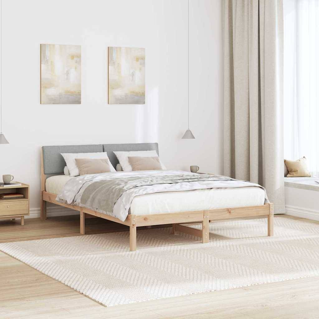Ein minimalistisches Schlafzimmer mit einem Holzbett, grauem Kopfteil und heller Bettwäsche. Zwei abstrakte Gemälde hängen an der Wand; natürliches Licht durchflutet den Raum.