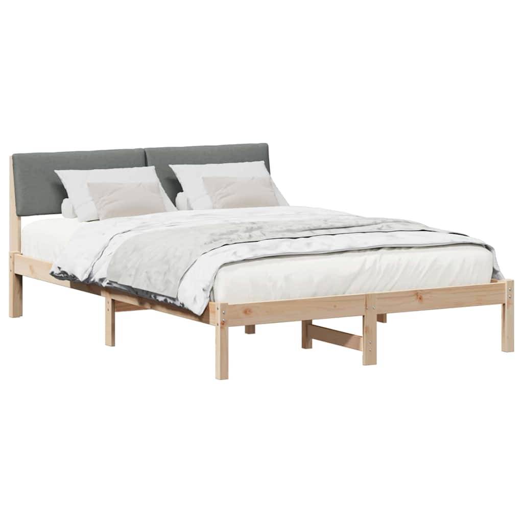 Ein Holzplattformbett mit einem dunklen Kopfteil, weißer Bettwäsche und zwei Kissen.