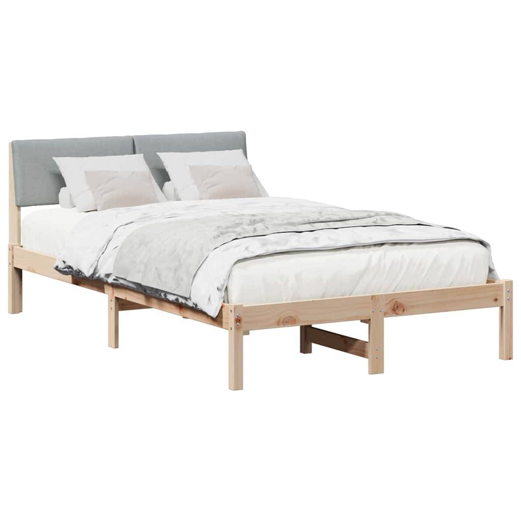 Ein Holzbettgestell mit einem grauen Stoffkopfteil, weißer Bettwäsche und zwei Kissen. Das Design ist schlicht und modern.
