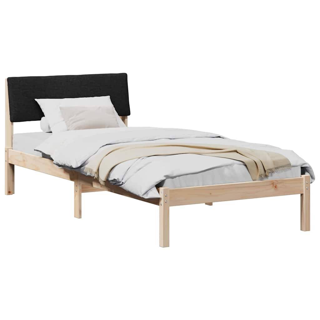 Ein einfacher Holzbettrahmen mit einem schwarzen gepolsterten Kopfteil. Das Bett ist mit weißer Bettwäsche und einer beigen Decke bezogen.
