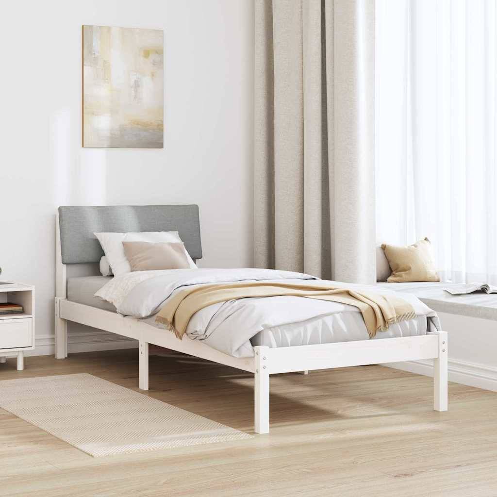 Ein minimalistisches Schlafzimmer zeigt ein weißes Bett mit grauem Kopfteil, beigefarbener Bettwäsche, einem Nachttisch, abstrakter Wandkunst und einem lichtdurchfluteten Fenster.