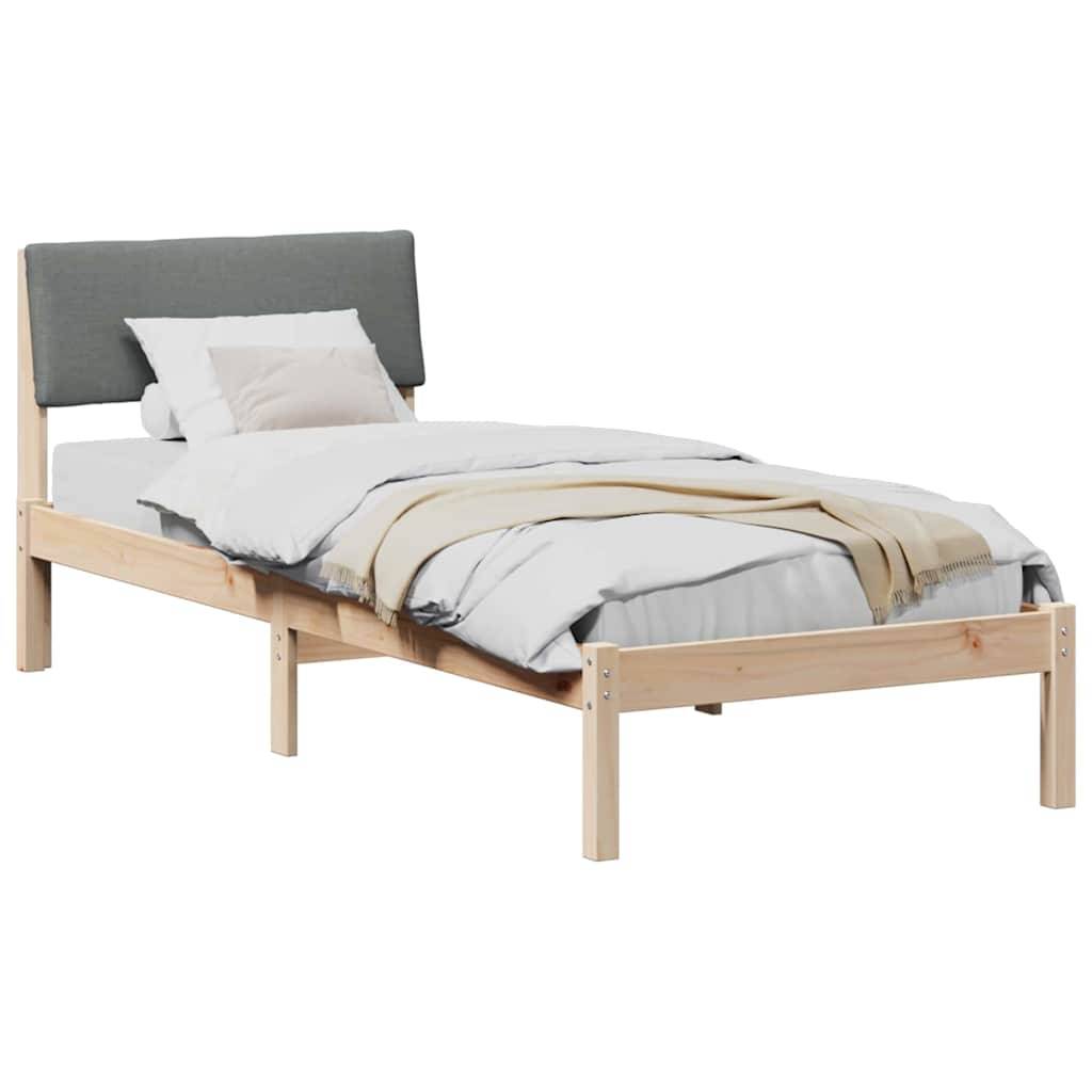 Ein Holzbett mit einer grau gepolsterten Kopfstütze, weißer Bettwäsche und einer beigen Decke.